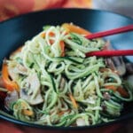 Zuccini noodles with mushrooms, peppers and carrots in a black bowl