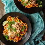 Bowl of sweet potato noodles topped with sliced chicken and lime.