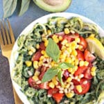 Bowl of zoodles topped with creamy sauce and stewed tomatoes.