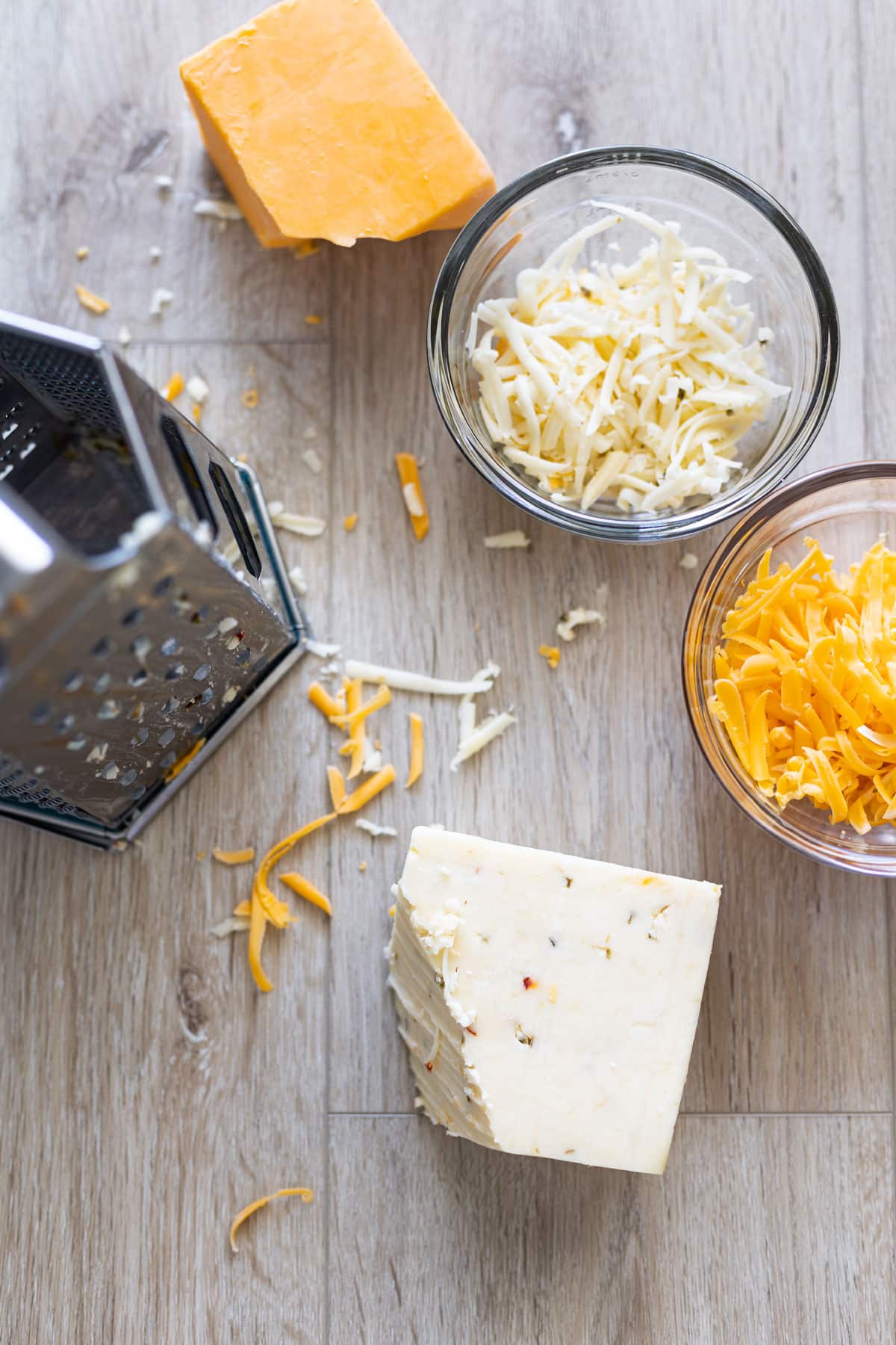 Shredding blocks of cheese with a cheese grader. 