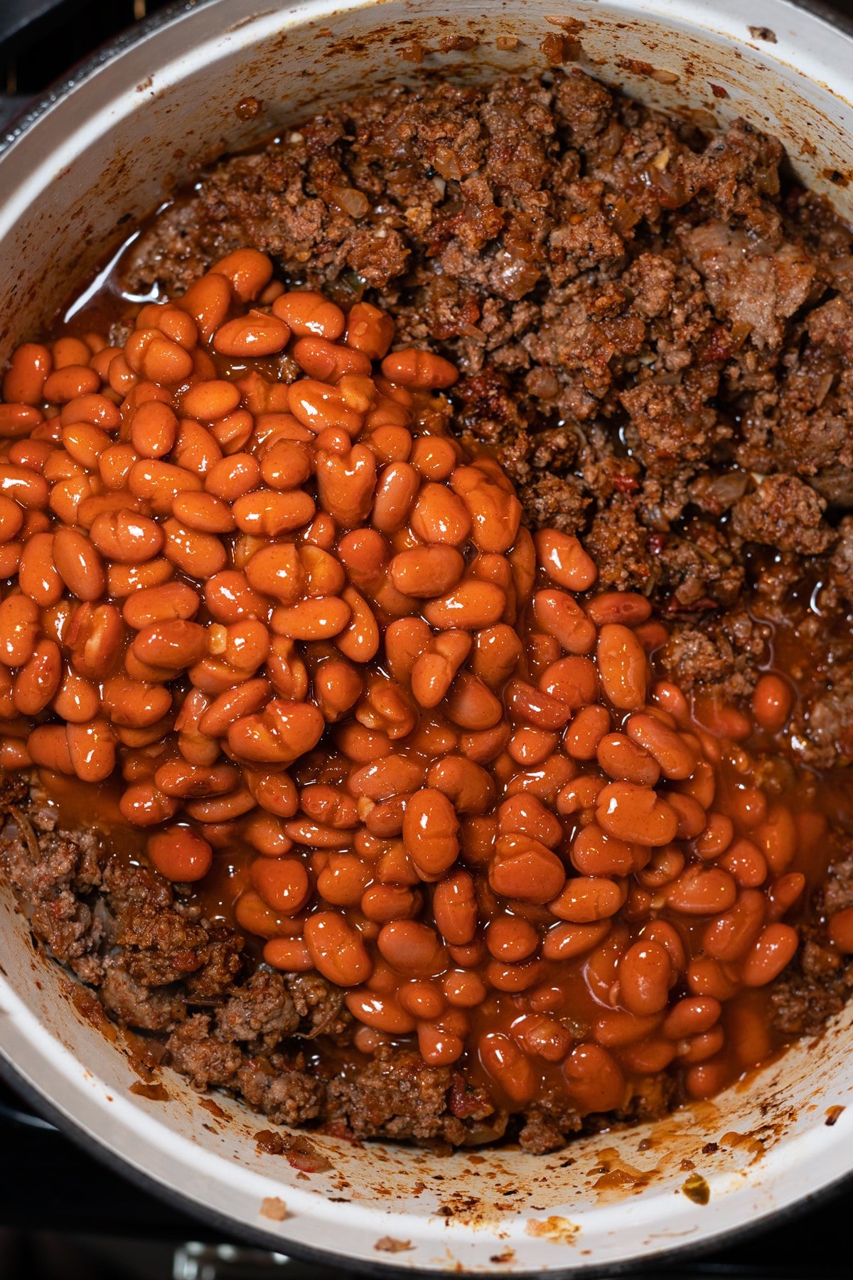 Beans in a pot with ground beef simmering. 