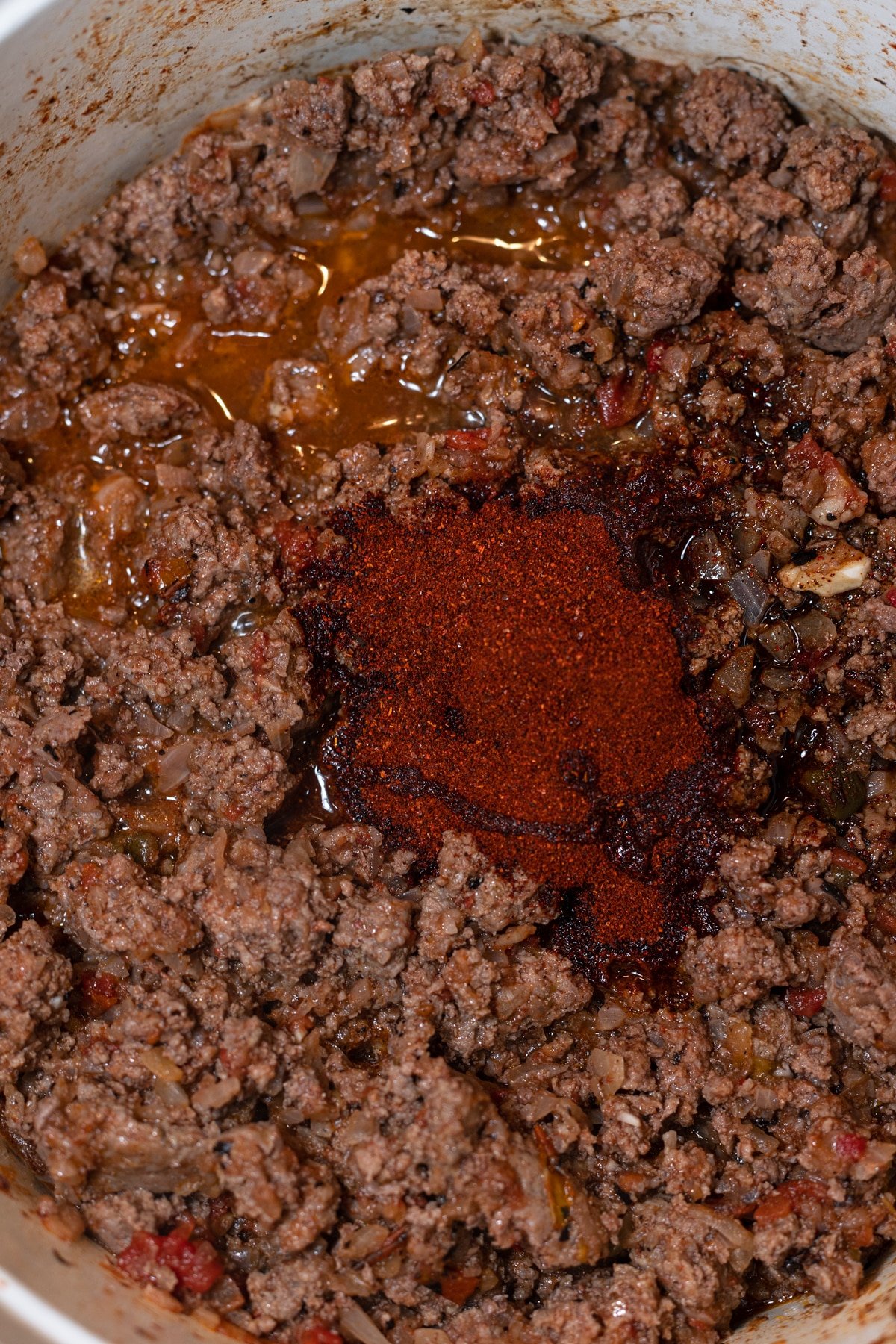 Seasonings in a pot with ground beef. 