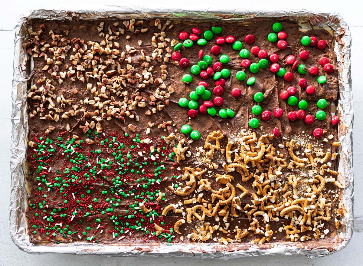 A cookie sheet of Christmas crack topped with a variety of toppings.