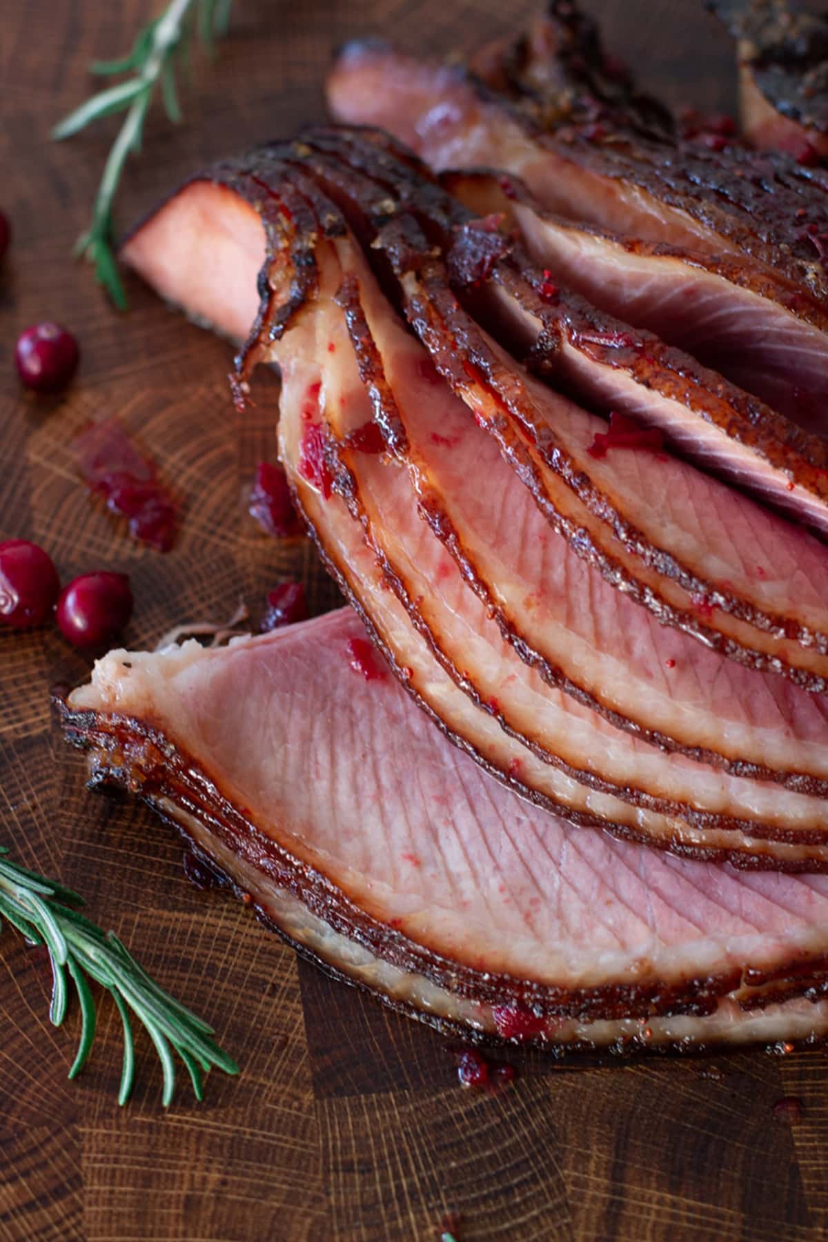 Sliced spiral ham covered in cranberry butter. 