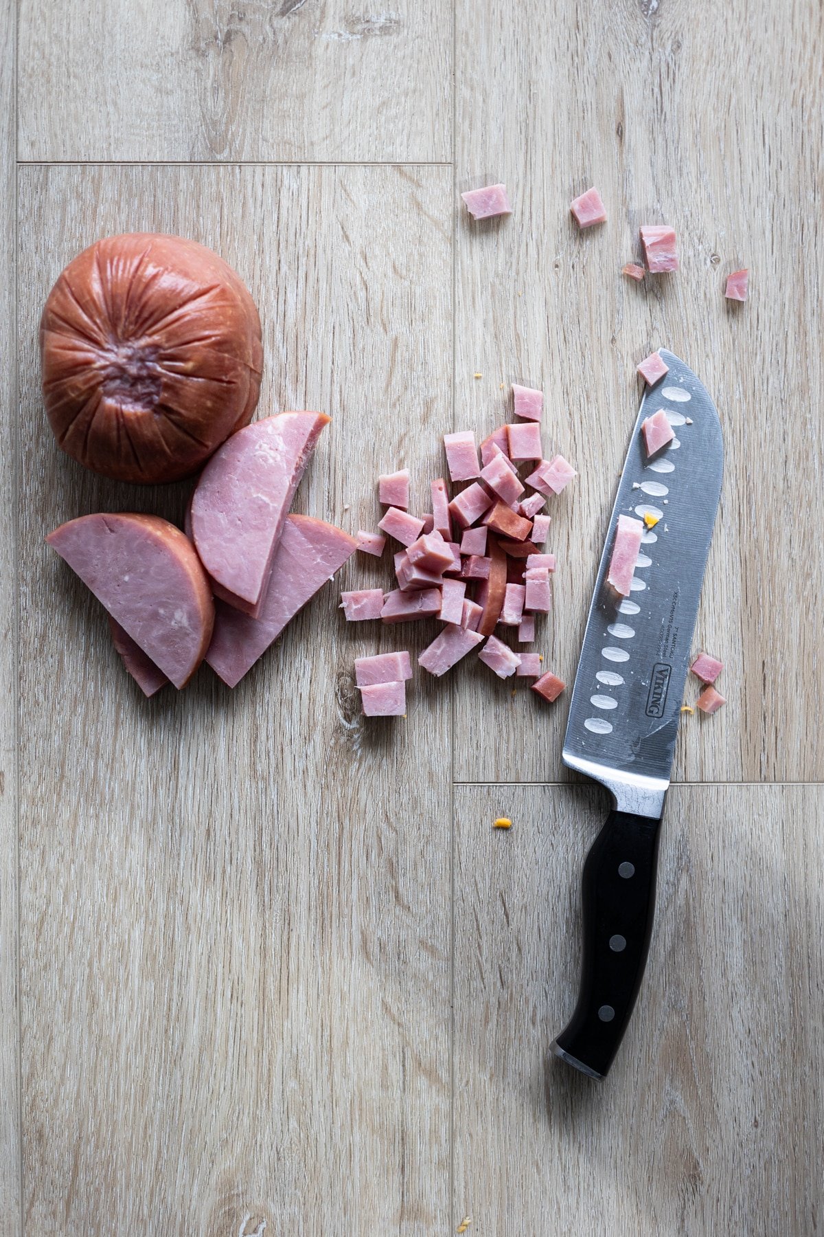 Knife on counter next to cubed ham. 