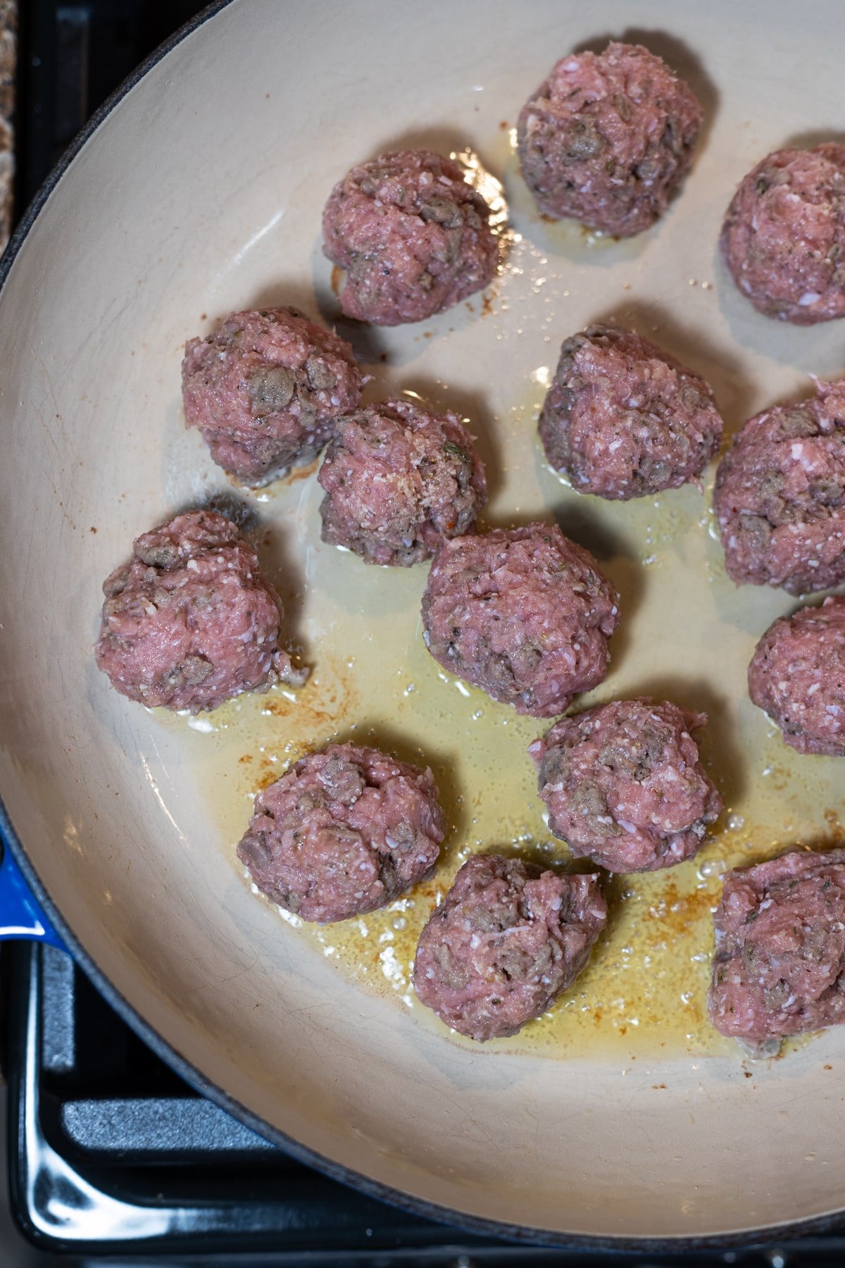 Sauteing meatballs in a skillet. 