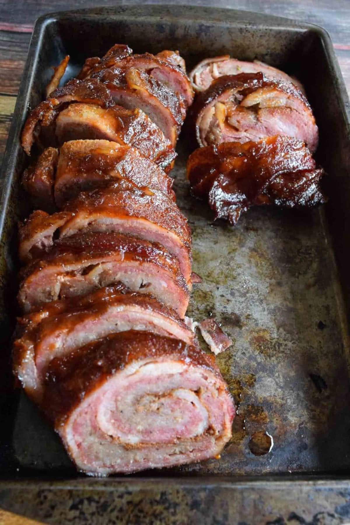 Slices of rolled pork and bacon on a serving patter. 