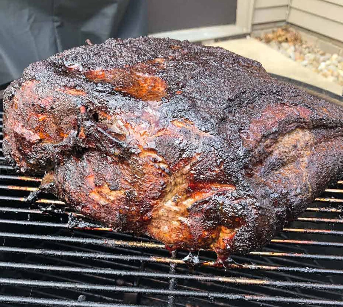 Pork butt on smoker grill grates. 