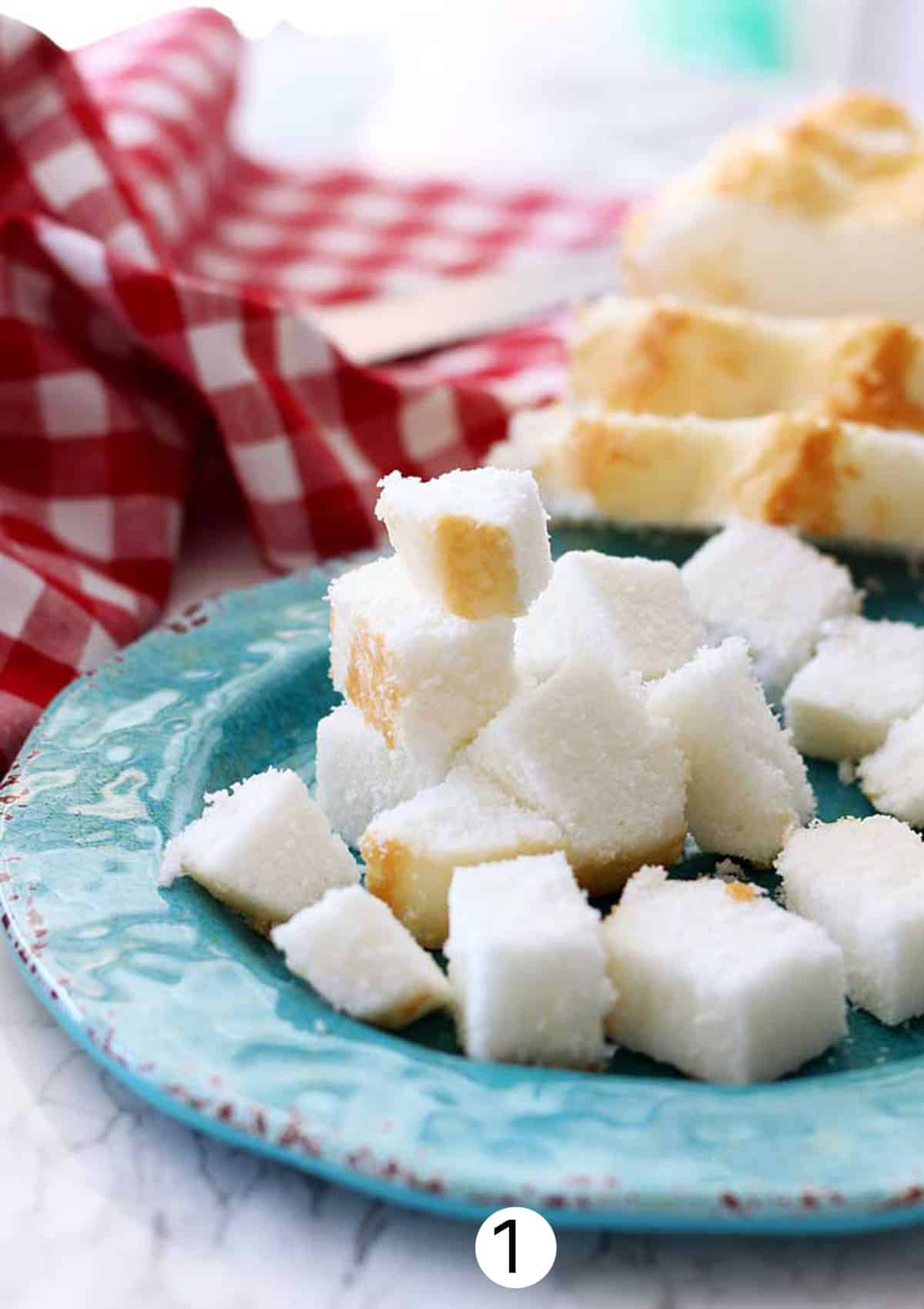Cubed pieces of angel food cake on a plate.