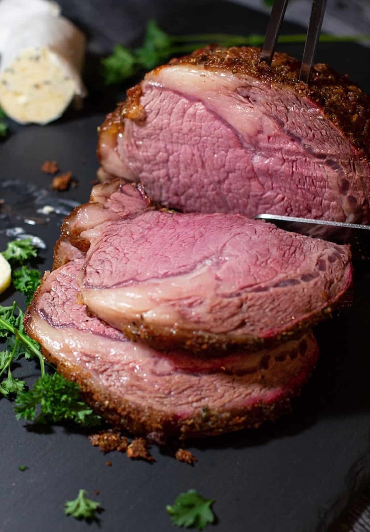 Person slicing prime rib.