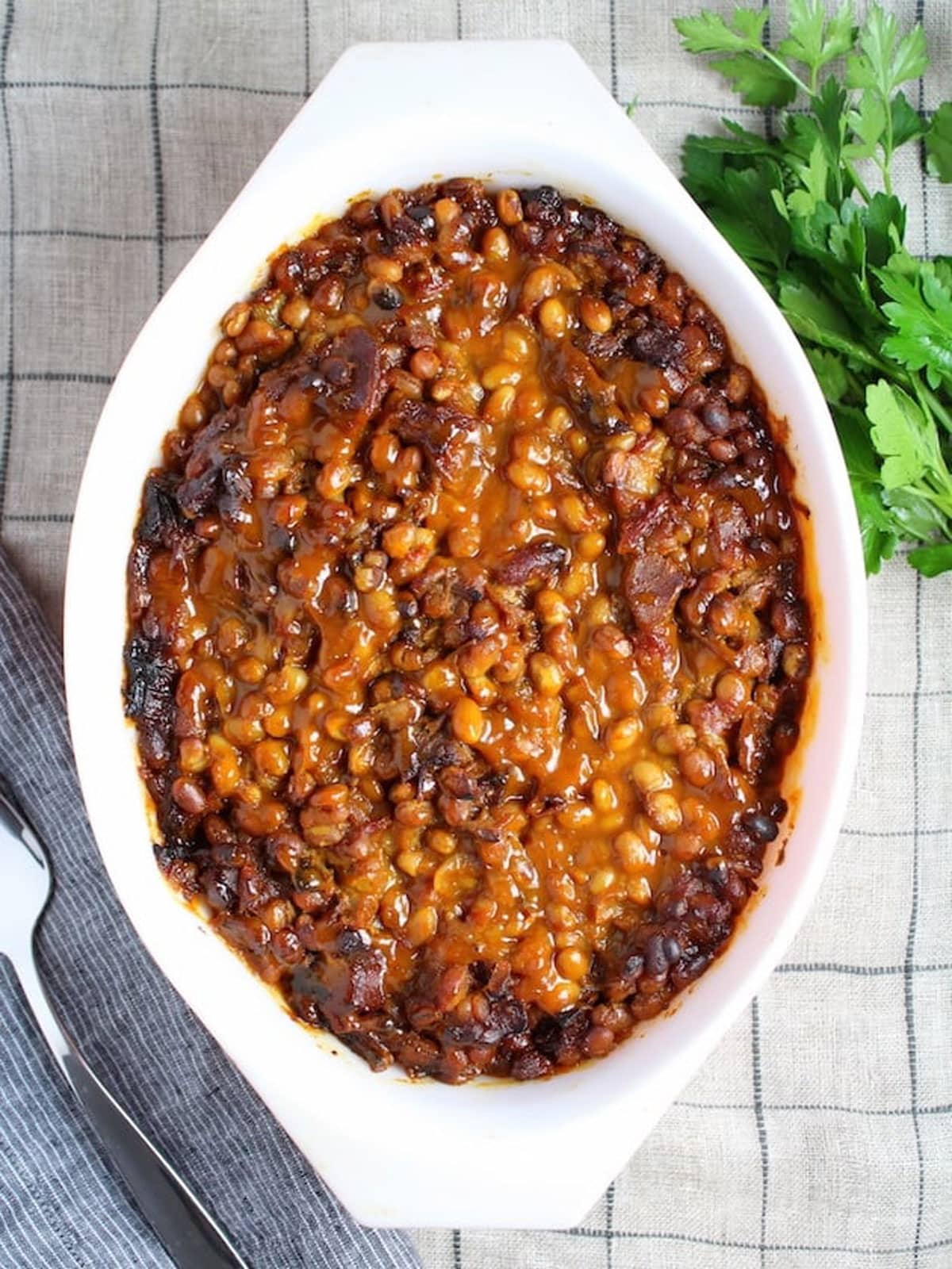 Baking dish filled with baked beans sitting on a counter.