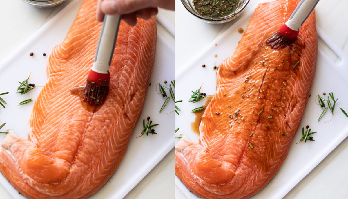 Person basting glaze on top of salmon.