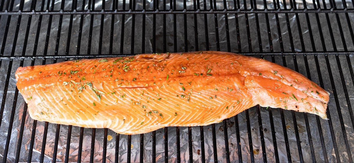 Salmon smoking on a grill grate. 