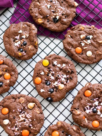 Halloween chocolate cookies next to each other on parchment paper.