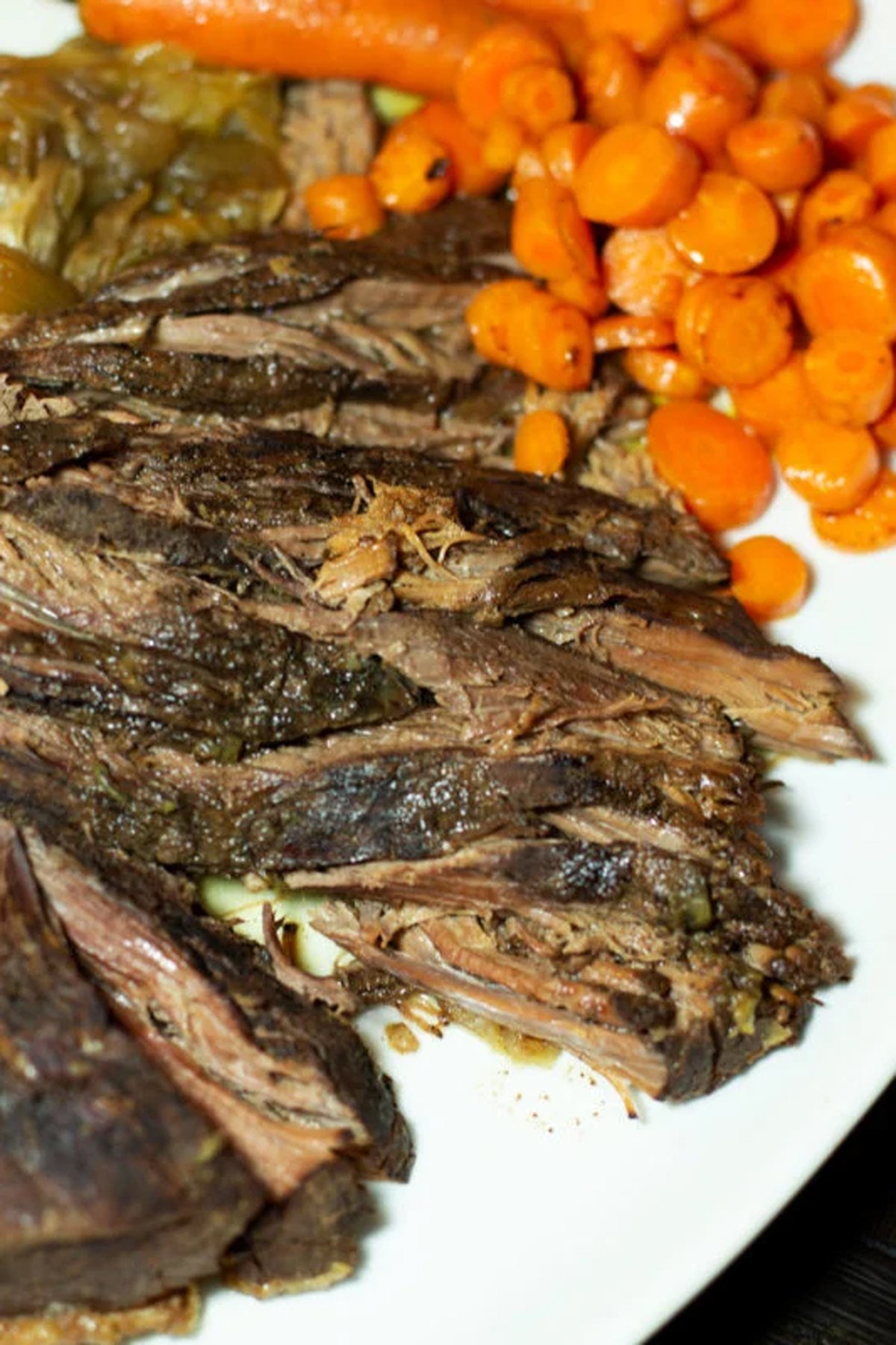 Plate being served with slow cooker beef brisket with steamed carrots. 