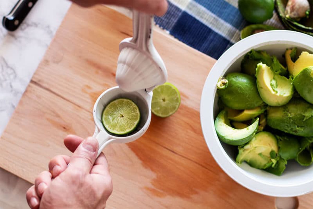 Using a citrus press to juice a lime. 