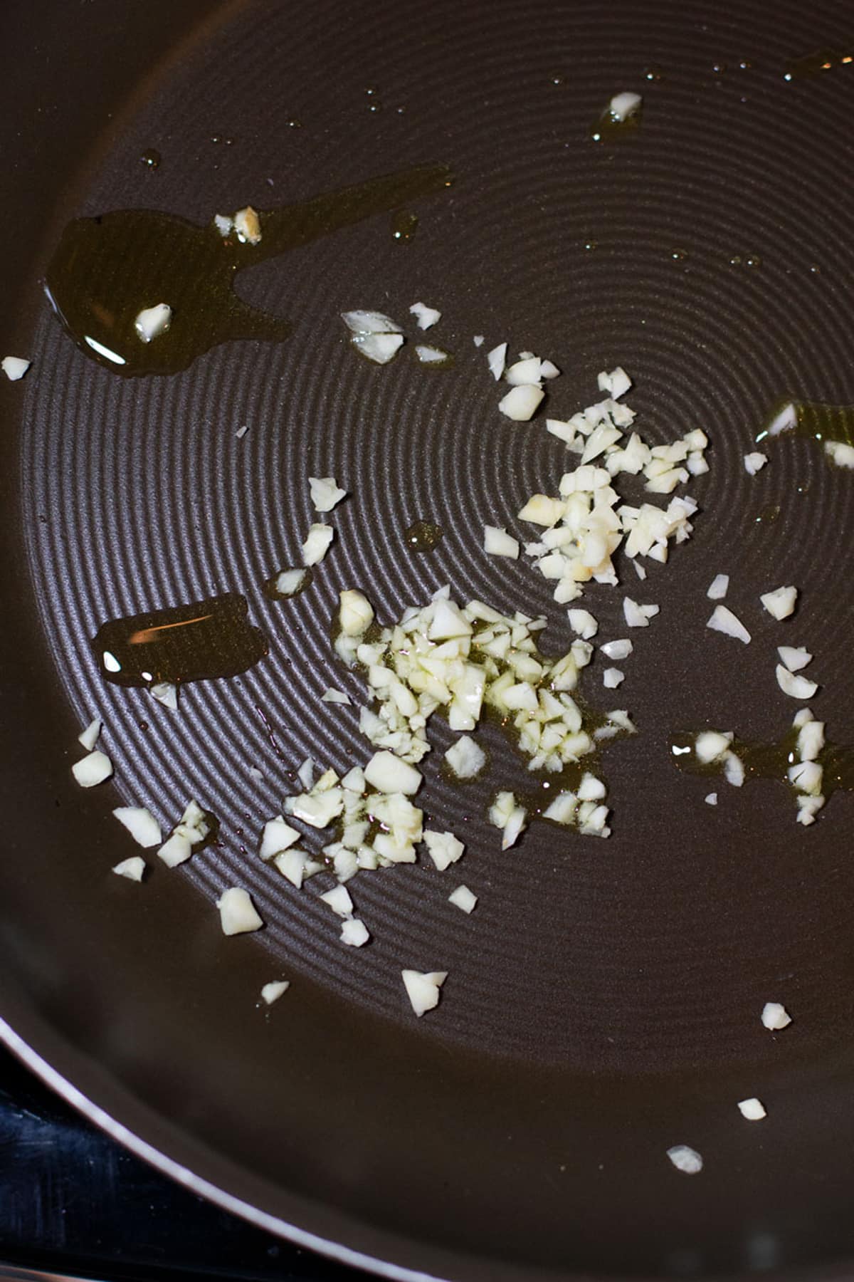 Minced garlic being sautéed in a skillet.