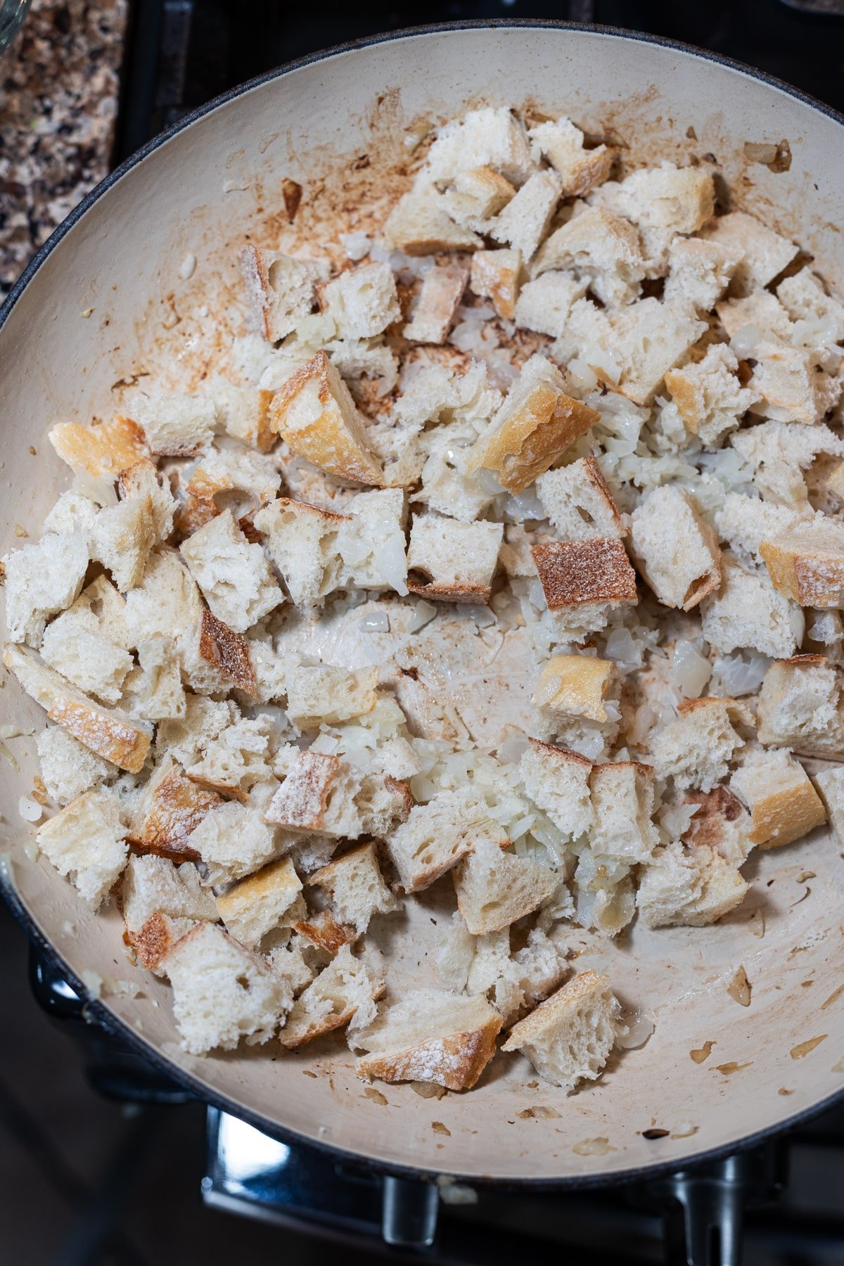 Fresh bread being mixed with onions, garlic, and butter.