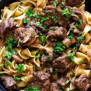Close up of beef tips served over egg noodles.
