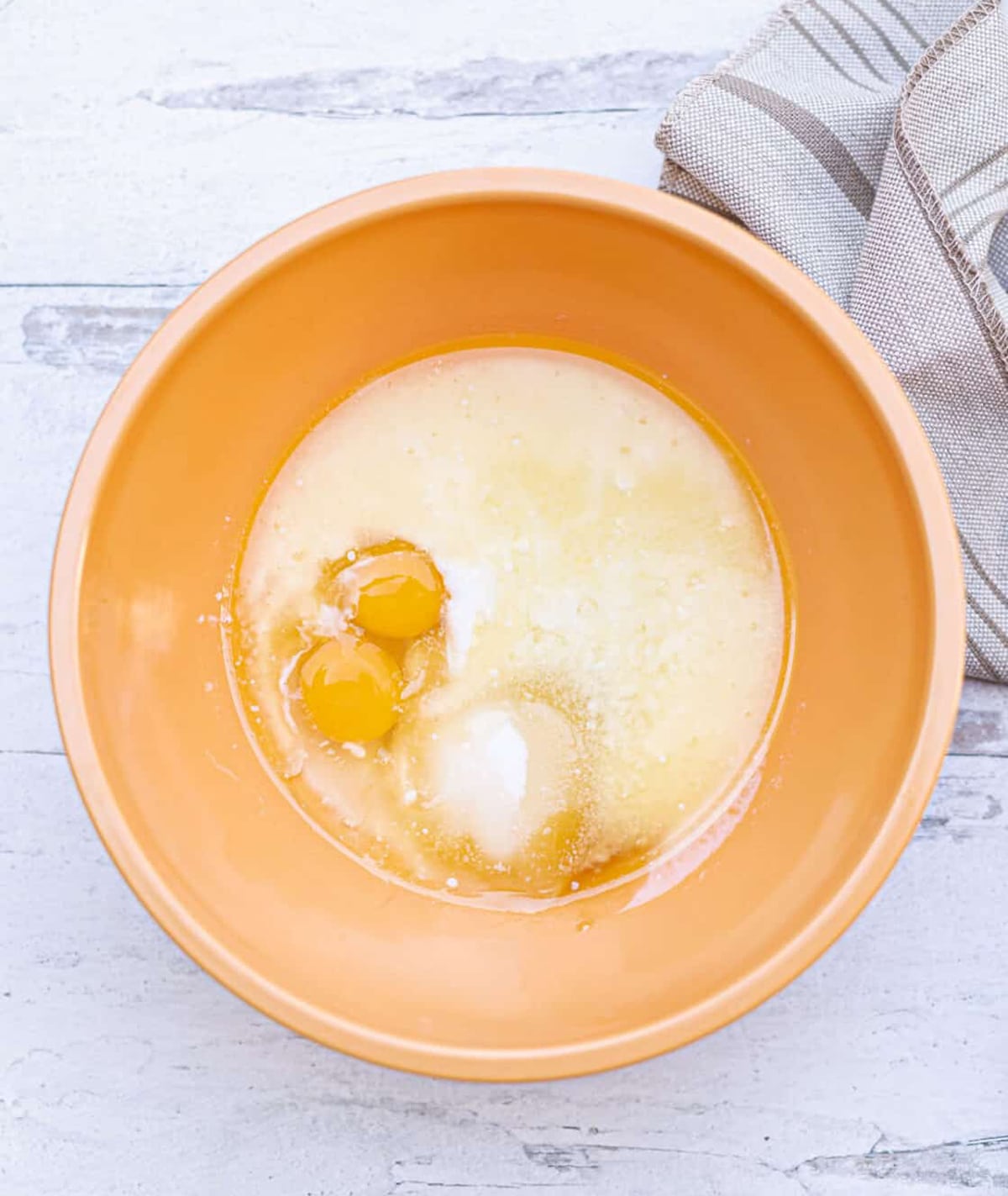 Large bowl filled with cornmeal, eggs, and sugar and butter.