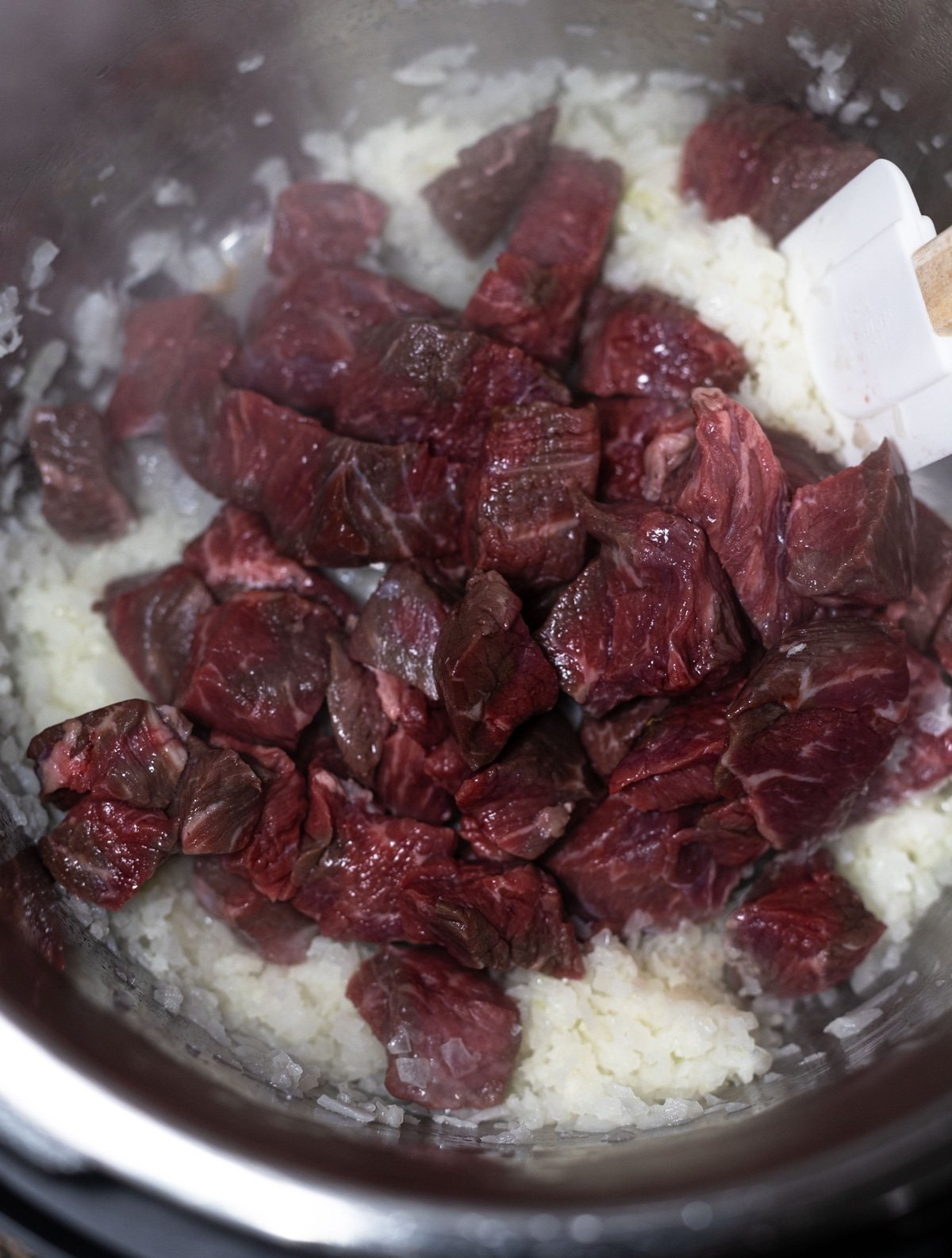 Raw beef stew meat in an instant pot. 