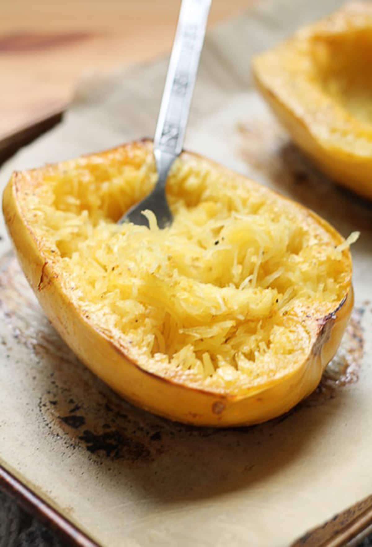 Person using a fork to scrape spaghetti squash. 