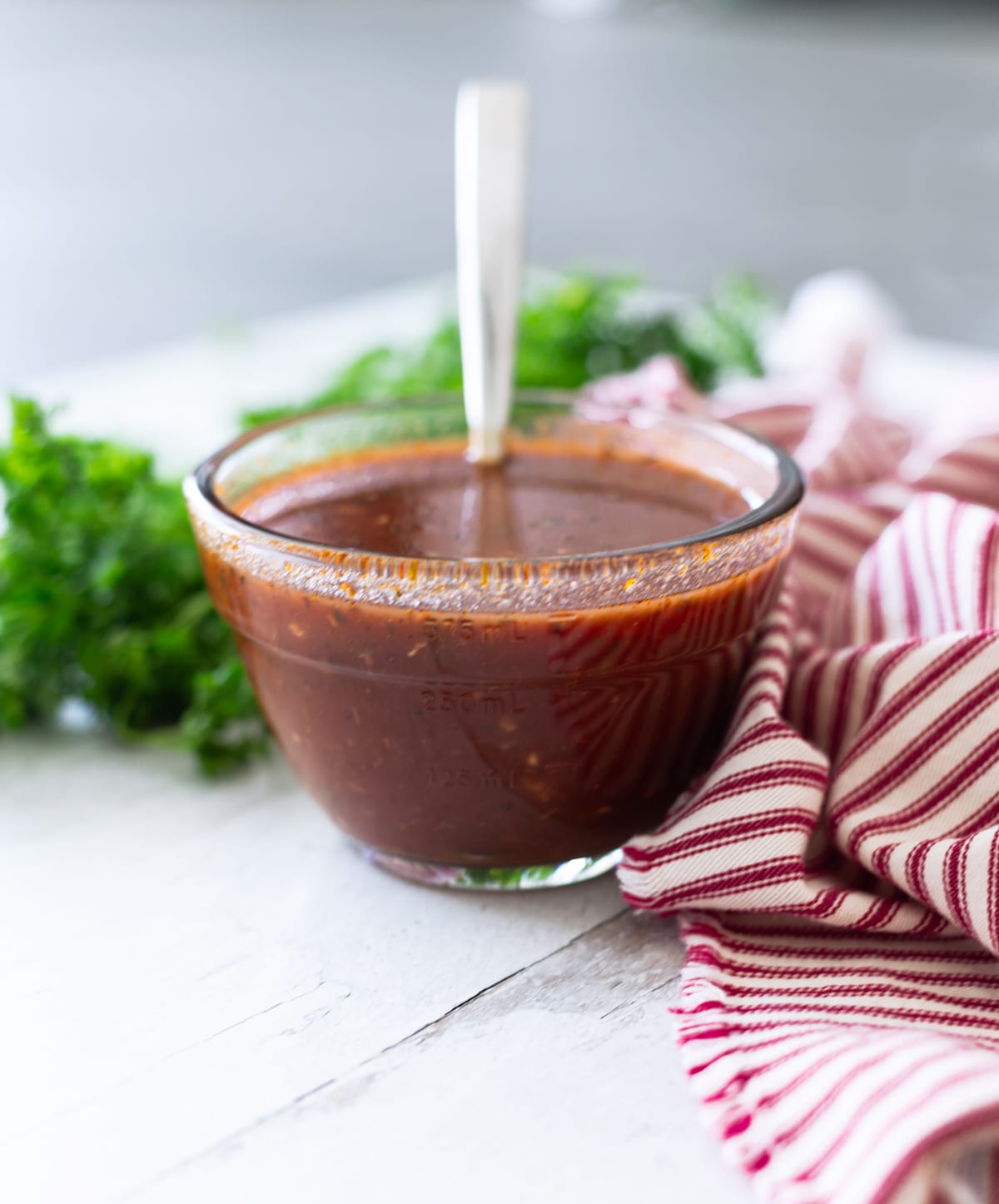 Red enchilada sauce in a glass container on a counter.