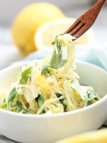 Person using a fork to take a bite of spaghetti squash.