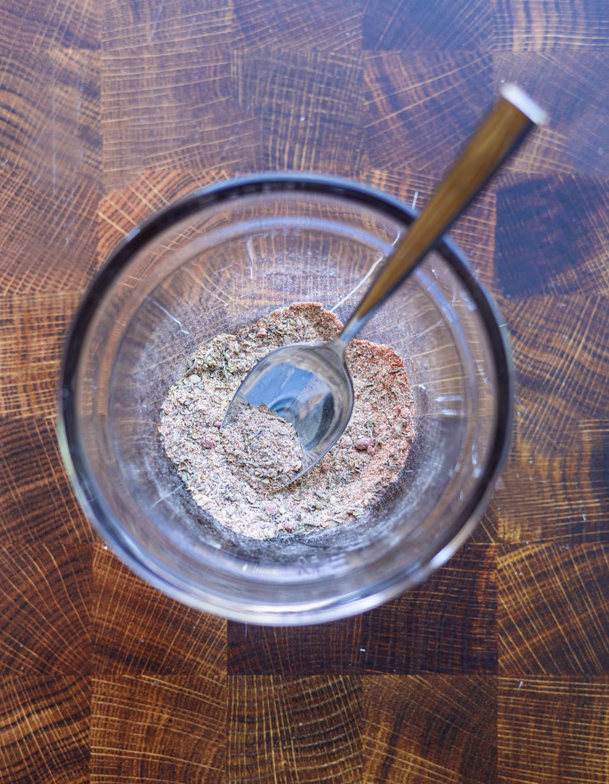 Glass bowl filled with seasonings for making chicken.