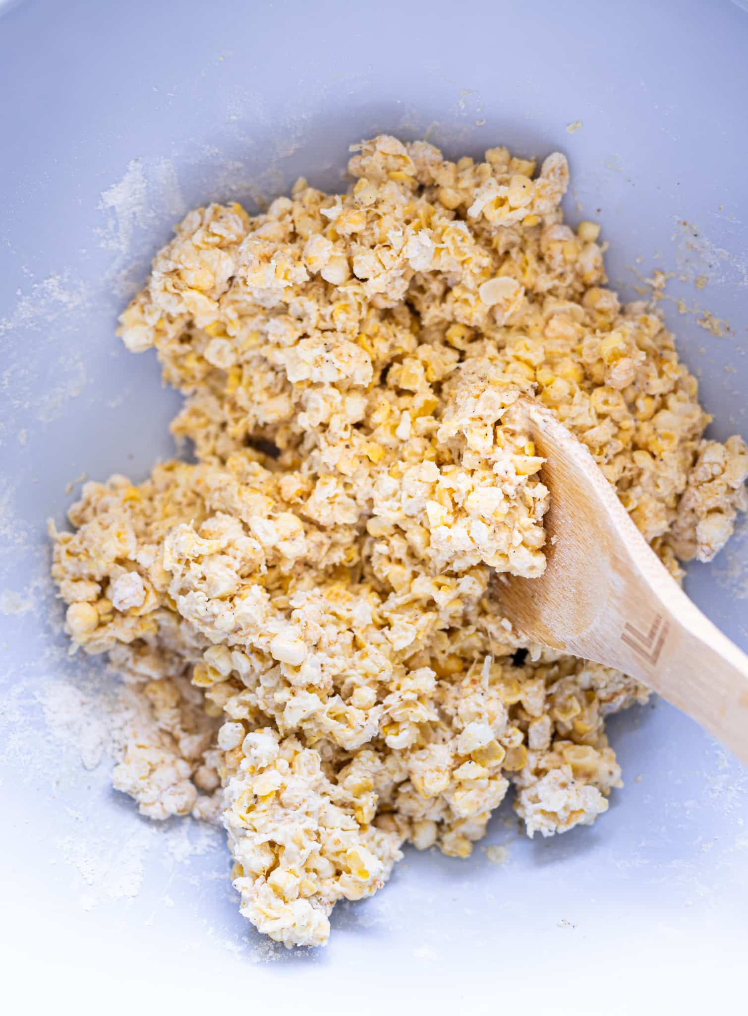 Corn and flour being stirred in a bowl. 