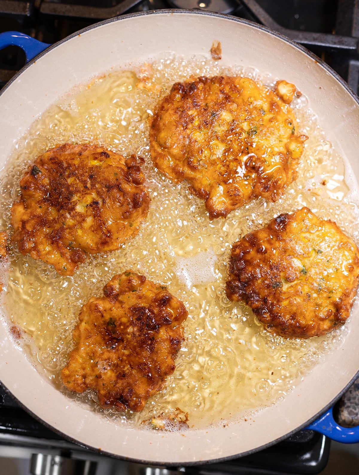 Corn Fritters deep frying in a pan.