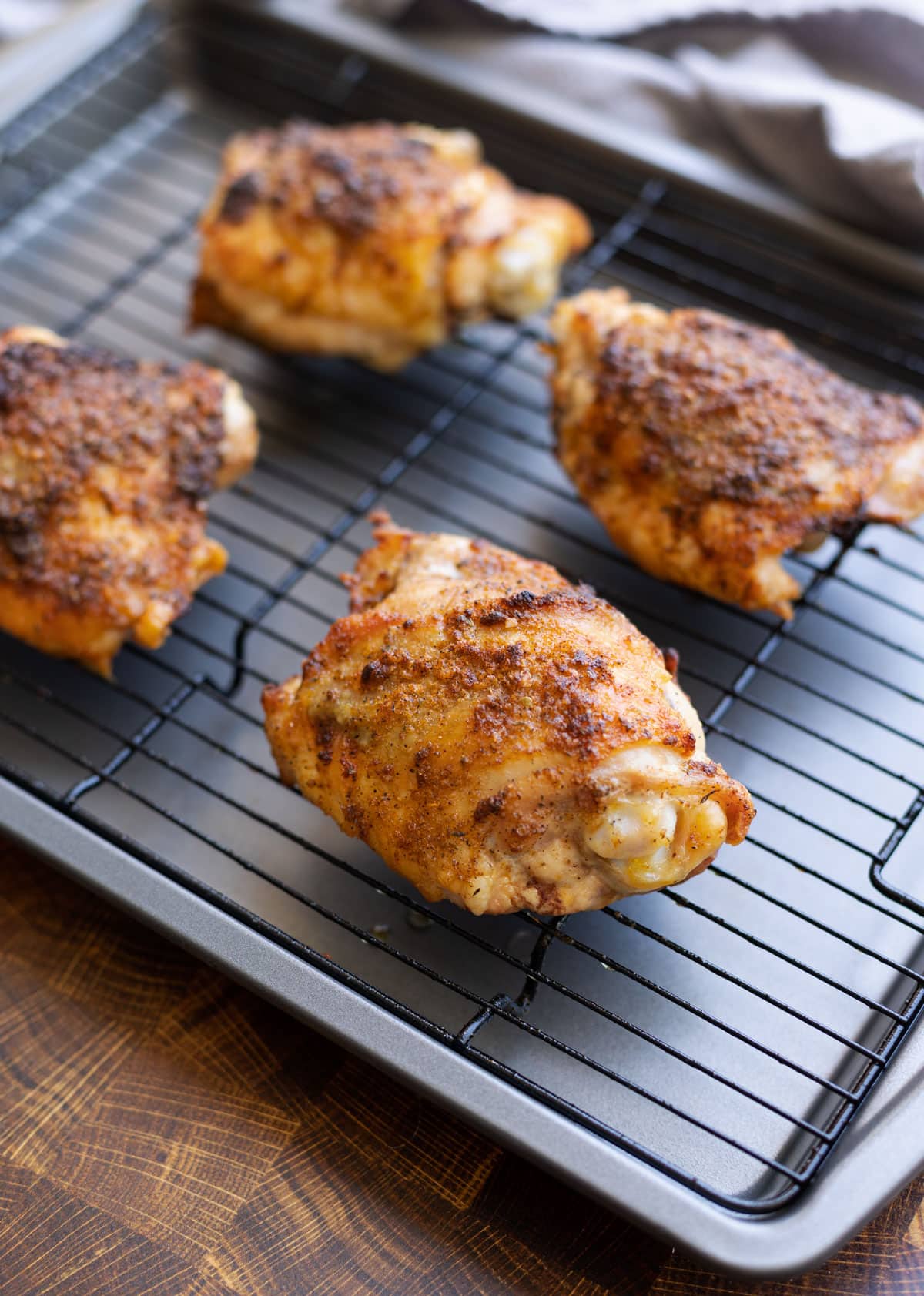 4 pieces of chicken cooling on a wire rack.