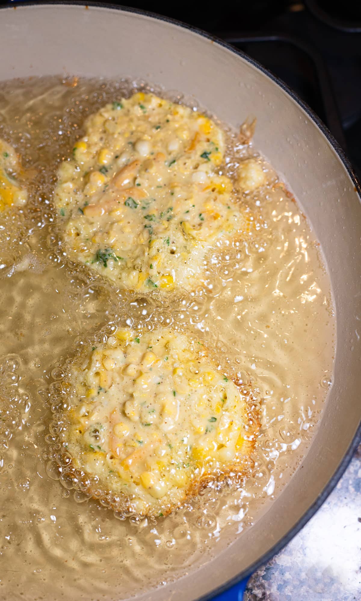 Corn fritters in a skillet.