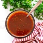 Bowl of homemade red enchilada sauce on a counter.