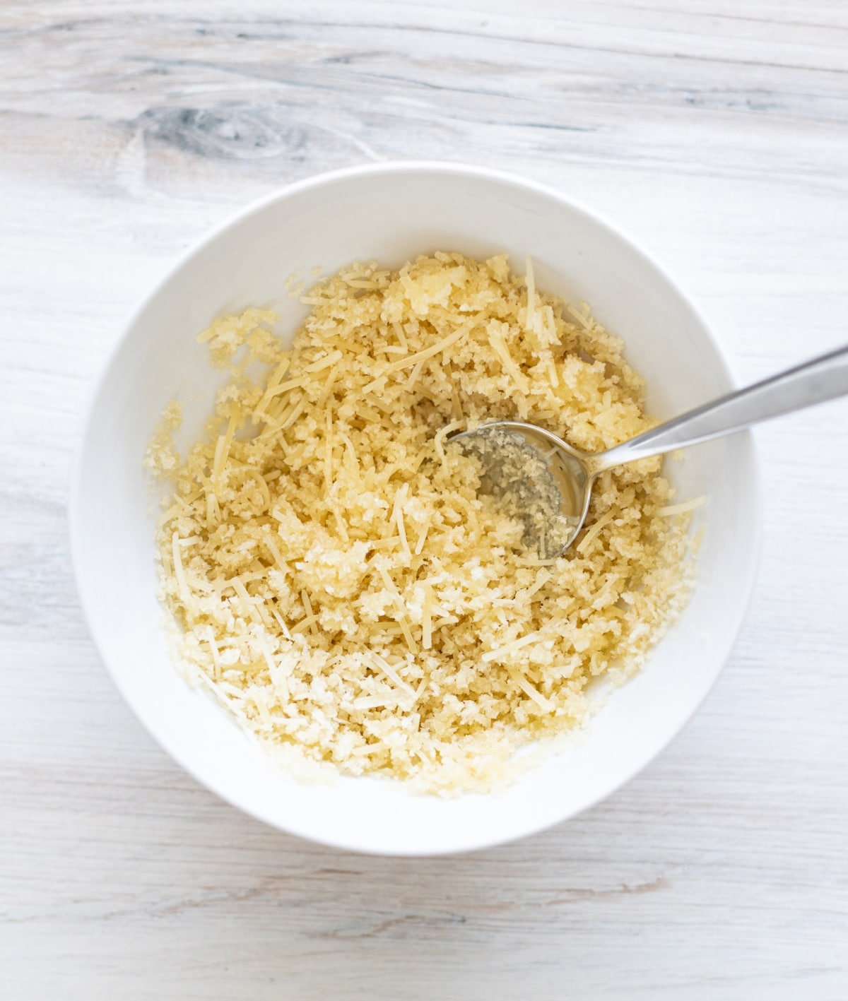 Bowl filled with shredded Parmesan cheese. 