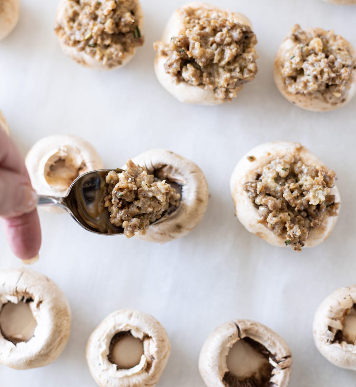 Person stuffing mushrooms. 