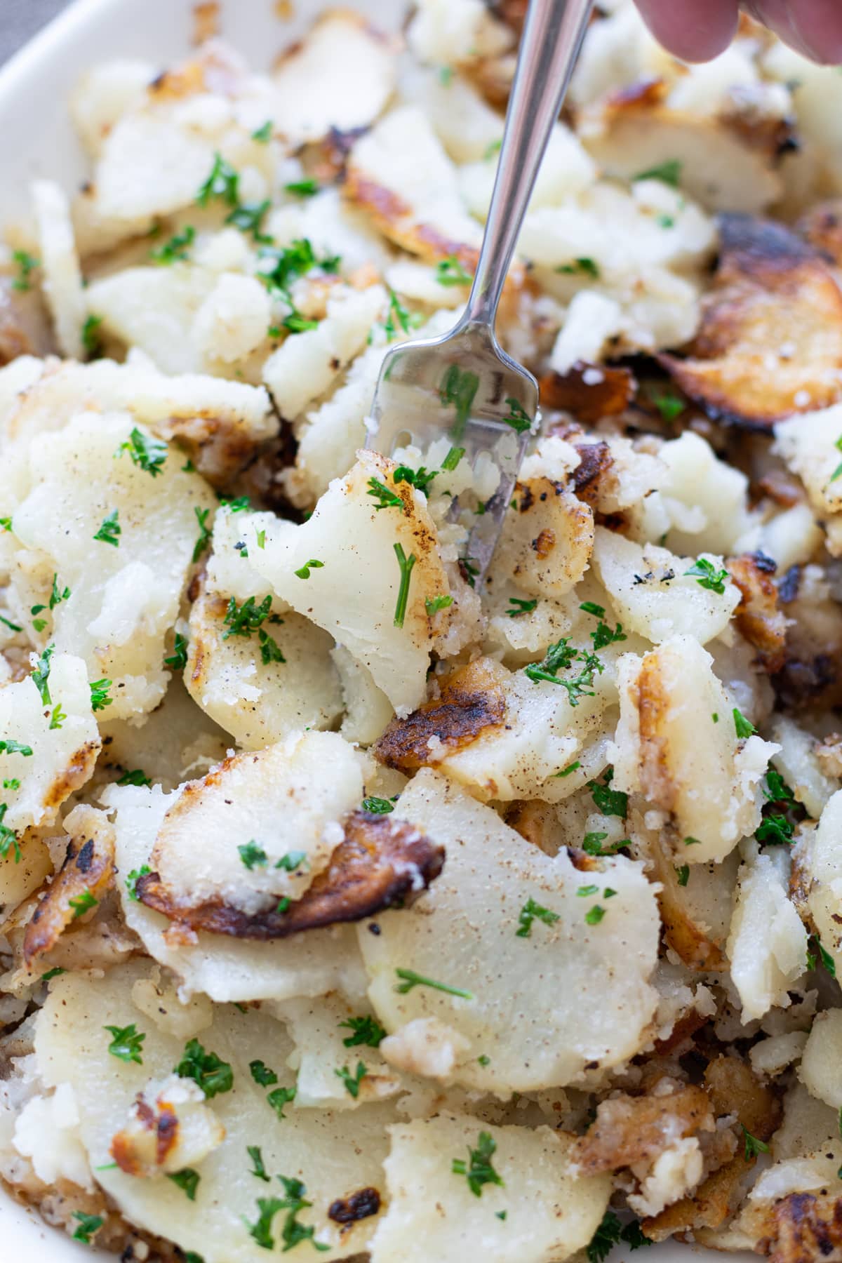 Person eating potatoes with a fok.