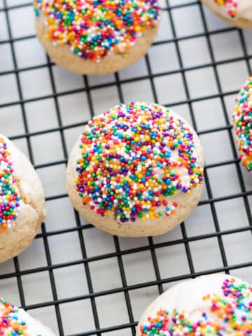Anise cookie cooling on a wire rack topped with sprinkles.