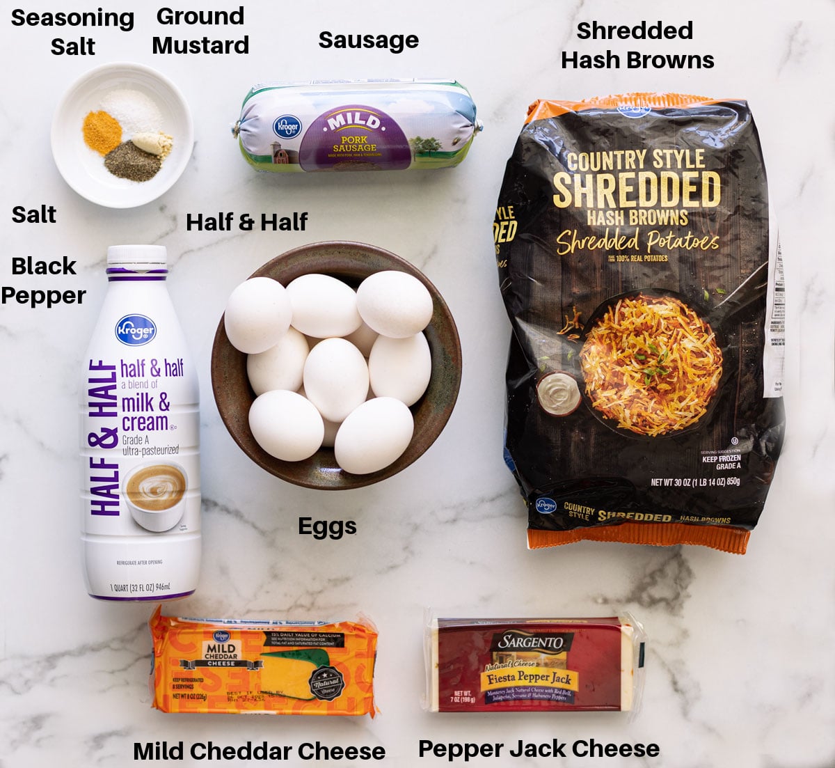 All of the ingredients you need to make hash brown breakfast casserole: hash browns, eggs, half and half, sausage, cheese, ground mustard, seasoning salt, salt, and pepper. 