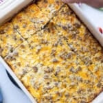 Person slicing hash brown casserole getting ready to serve it to eat.