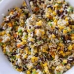 Close up of spoon filled with corn and black bean salad.