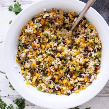 Bowl filled with corn and black bean salad reacy to be served.