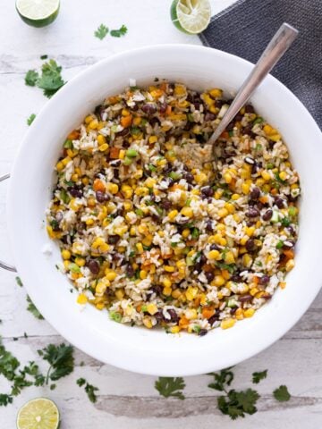 Bowl filled with corn and black bean salad reacy to be served.