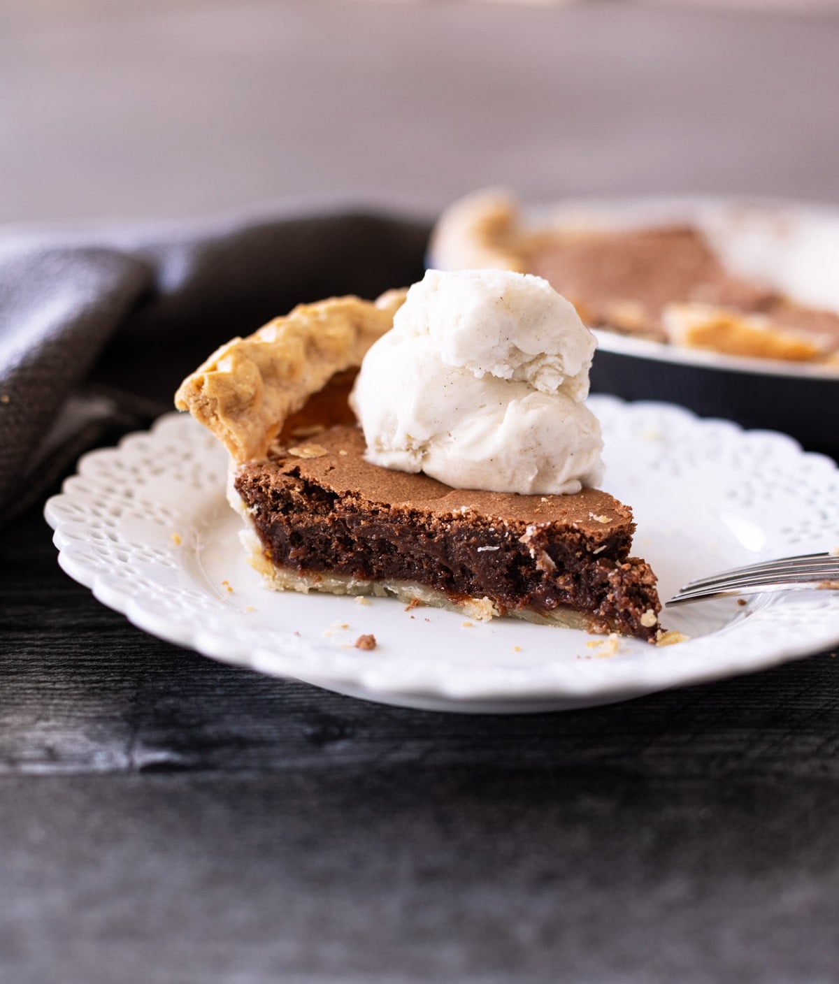 Slice of homemade chocolate pie on a plate topped with whipped cream.
