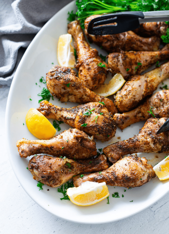 Platter filled with oven baked chicken legs.