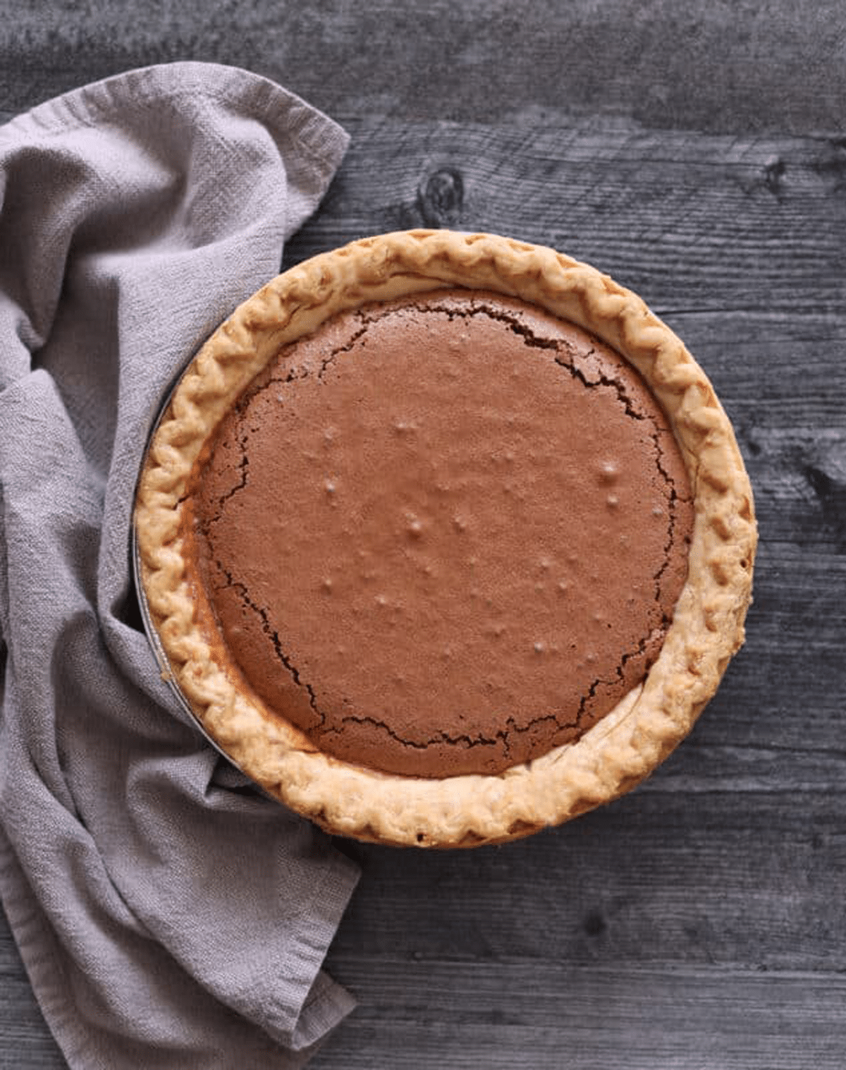 Baked chocolate pie cooling on a counter.