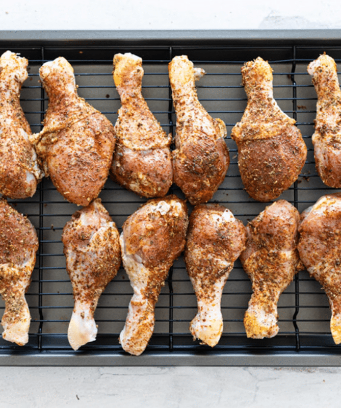 Seasoned drumsticks getting ready to be baked in the oven.
