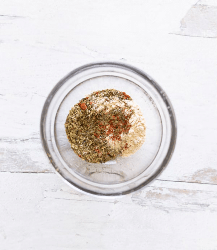 Glass bowl filed with seasoning for poultry.