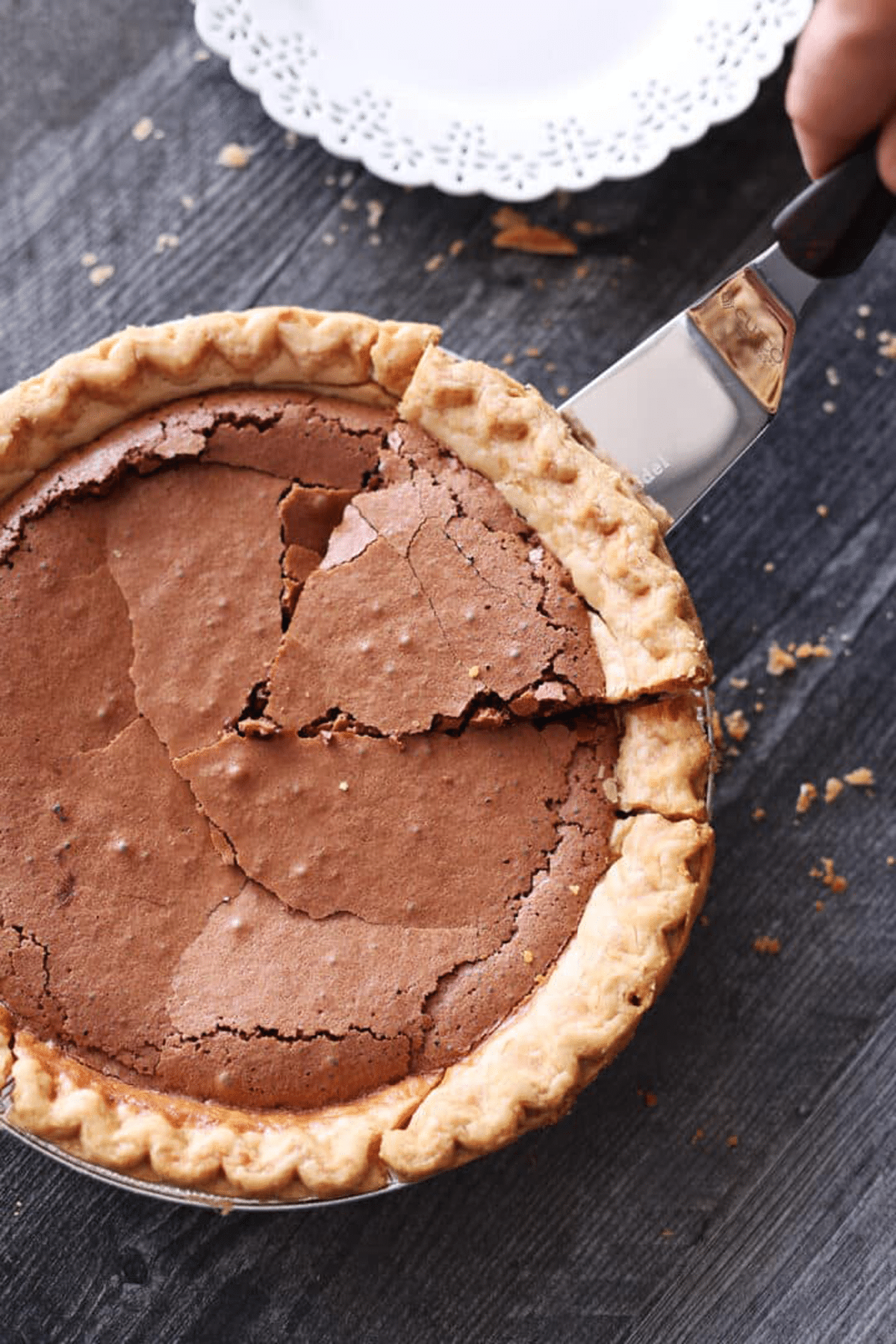 Person serving a piece of chocolate pie.