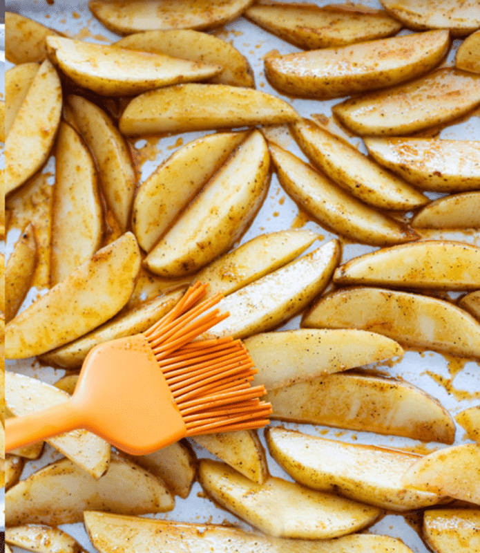 Person basting on evenly the oil and seasoning for steak fries.